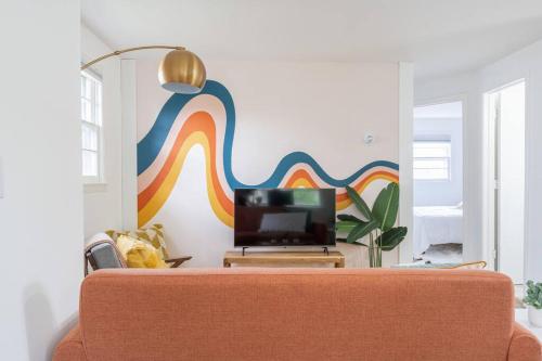 a living room with a couch and a colorful wall at Double The Fun II Two Houses and fire pit in shared yard in Kingston