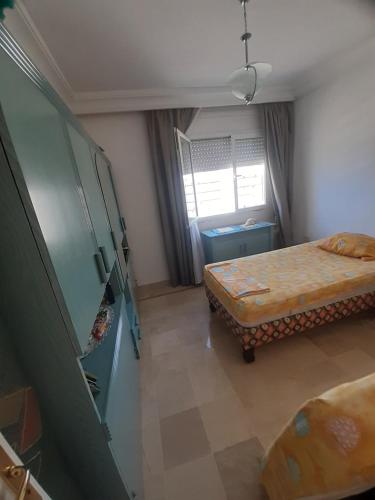a small room with two beds and a window at Afnane 3 in Chott Meriem