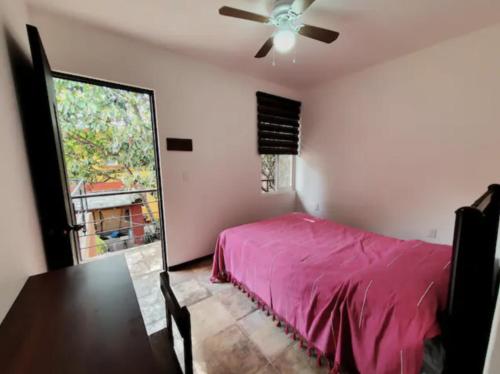 Casa Juárez 2 في مدينة أواكساكا: غرفة نوم بسرير ومروحة سقف