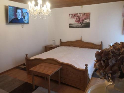 sypialnia z dużym łóżkiem i żyrandolem w obiekcie Landhaus-Ferien-Sommer w mieście Bleckede