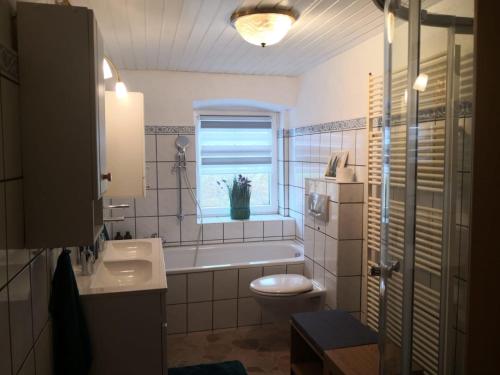 ein Bad mit einer Badewanne, einem WC und einem Fenster in der Unterkunft Landhaus-Ferien-Sommer in Bleckede