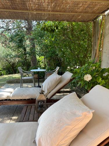 a porch with two beds and a table and trees at Podere Gattabigia in Lastra a Signa