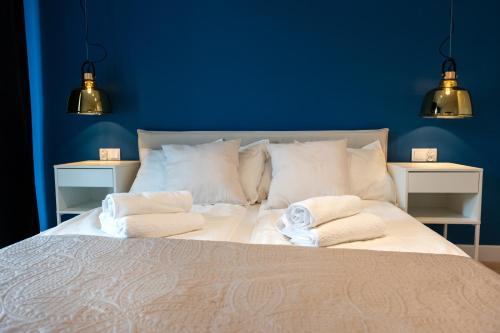 ein blaues Schlafzimmer mit einem Bett mit Handtüchern darauf in der Unterkunft Waveside Apartments and SPA Dziwnów in Dziwnów