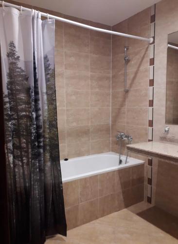 a bathroom with a tub and a shower curtain at Apartament by Zenit in Terra Complex C30 in Razlog