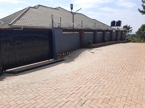 a house with a gate and a brick driveway at Deerwood Family Apartments, Bulenga in Bulenga