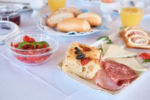 a table with a plate of food with bread and meats at Agriturismo Il Megalite in Giurdignano