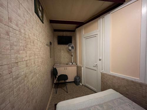 a small room with a bed and a desk with a fan at Sun in Khmelʼnytsʼkyy
