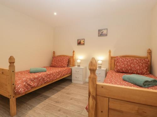1 dormitorio con 2 camas y 2 mesitas de noche en Badgers Sett en Lydney