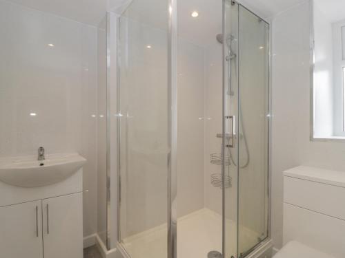 a bathroom with a glass shower and a sink at Badgers Sett in Lydney