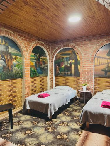 2 camas en una habitación con pinturas en las paredes en Veganamas en Vilna