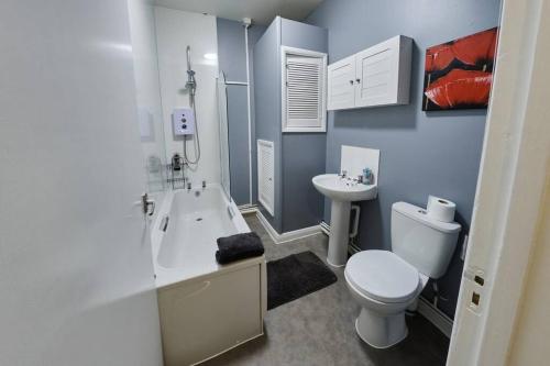 a white bathroom with a toilet and a sink at Central flat in Basingstoke in Basingstoke