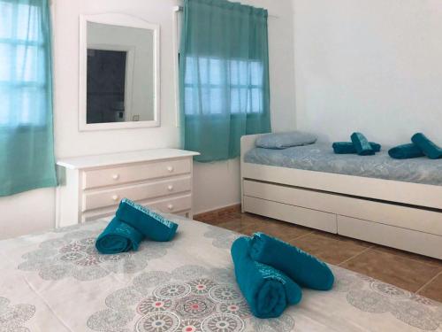 una camera con due letti con cuscini blu sul pavimento di Live Arico Lapa cerca de la playa a Arico