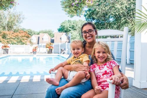 a woman and a little girl sitting next to a pool at Villa Signor in Norwich