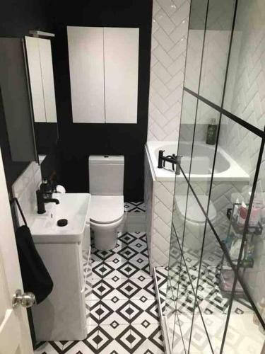 a bathroom with a toilet and a sink and a tub at Perfectly Positioned Pad in Cardiff