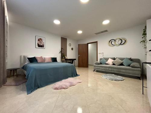a bedroom with a bed and a couch at LEO Apartment FREE PARKING - President Palace in Bratislava