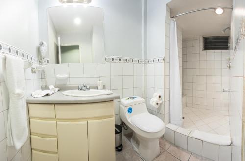 a bathroom with a toilet and a sink and a shower at Apartotel Tairona in San Pedro