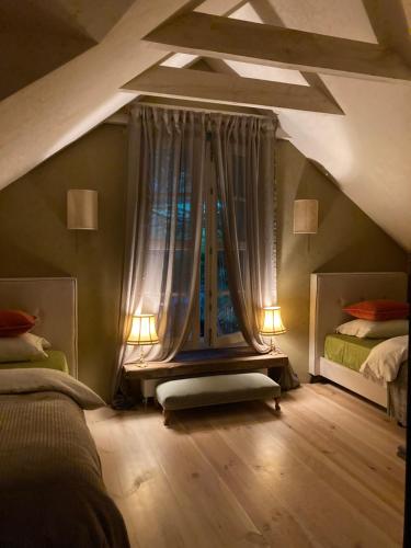 a attic bedroom with two beds and a window at Niebieski Koń in Kazimierz Dolny