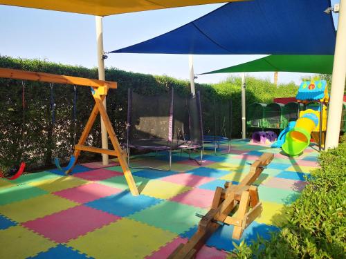 a colorful floor with a playground and an umbrella at Delta sharm resort. Studio. Sharm el sheikh in Sharm El Sheikh