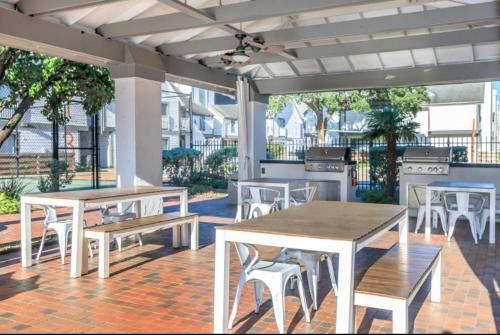 un grupo de mesas y sillas en un patio en The Cozy Clouds Resort at NRG, en Houston