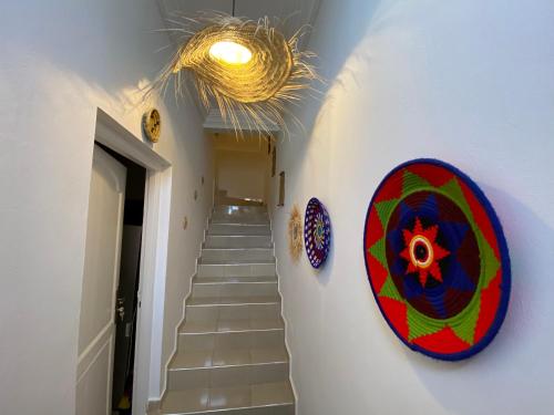 a hallway with stairs and a mirror on the wall at West coast surf house in Imsouane