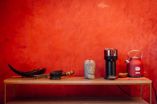 a coffee maker on a wooden table with a red wall at Maison du comte in Mexico City