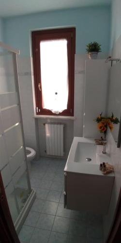 a bathroom with a sink and a window and a toilet at Casa Vacanze a 500mt dall'Autodromo Motodromo con parcheggio privato in Ottobiano