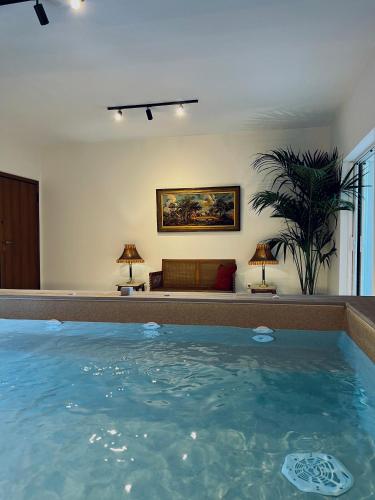 a large swimming pool in a room with a couch at THREE GRACES Apartments ZAKYNTHOS TOWN in Zakynthos Town