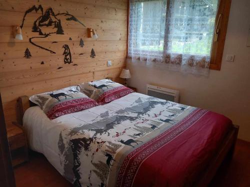 - une chambre avec un lit et un mur en bois dans l'établissement Charmant 3P avec Terrasse & Jardin, Proche Commerces et Téléphérique - FR-1-464-26, à Pralognan-la-Vanoise