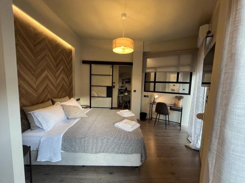 a bedroom with a bed and a desk in a room at METEORITO central apartment in Kalabaka