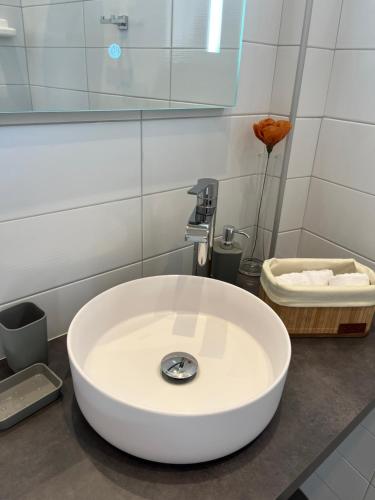 a white sink in a bathroom with a mirror at METEORITO central apartment in Kalabaka