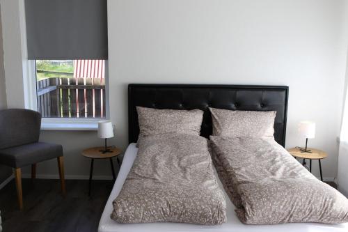 una camera da letto con letto con testiera e cuscini neri di Grímsstaðir holiday home - Family friendly a Reykholt