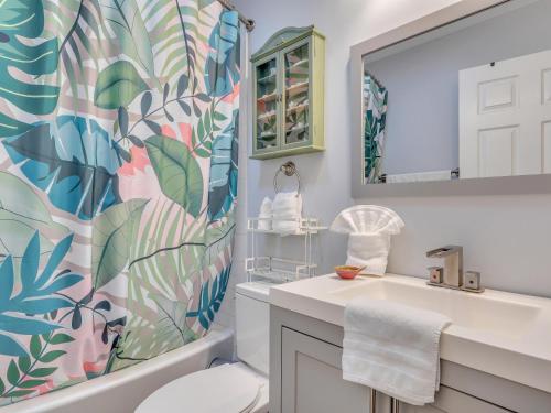 a bathroom with a sink and a toilet and a mirror at Salt Palms Cottage in Tybee Island