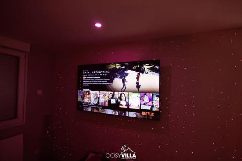 TV de pantalla plana colgada en la pared en CosyVilla - Spa Sauna Hammam, 