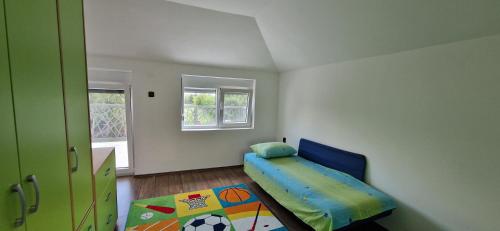 ein kleines Schlafzimmer mit einem Bett und einem Fenster in der Unterkunft Vila Elena in Niš