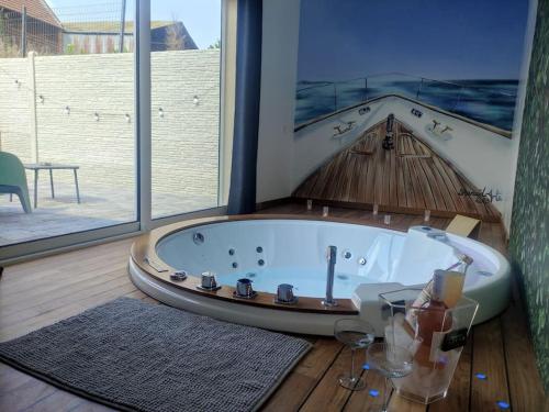 a bath tub in a room with a large window at CosyVilla - Spa Sauna Hammam 