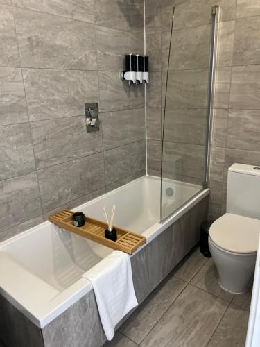 a bathroom with a bath tub and a toilet at 2 bedroom flat in London