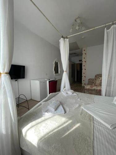 una camera da letto con un grande letto con tende bianche di Hotel Prestige a Alba Iulia