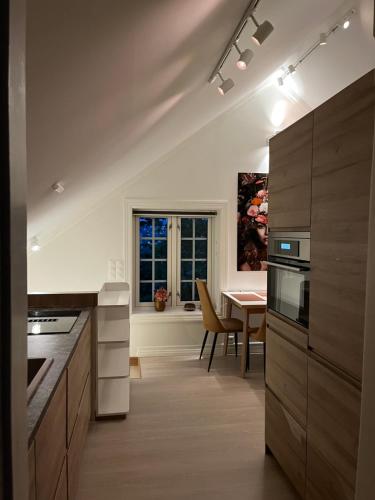 a kitchen with a table and a dining room at Bo i historisk bygning, kort vei til sentrum in Trondheim