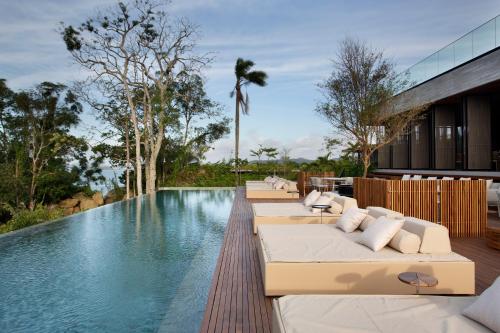 een overloopzwembad met ligstoelen en een resort bij Fuso Concept Hotel in Florianópolis
