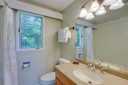 ein Badezimmer mit einem Waschbecken, einem WC und einem Spiegel in der Unterkunft Winhall Home with Sauna Less Than 1 Mi to Stratton Mountain! in Stratton Mountain