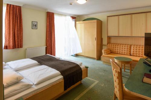 a hotel room with a bed and a couch at Alpinhotel Maistatt in Schladming