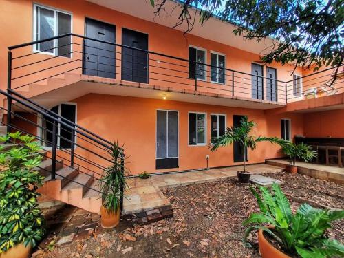 an orange house with a balcony and some plants at Casa Juárez 2 in Oaxaca City
