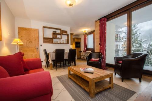 - un salon avec un canapé rouge, des chaises et une table dans l'établissement Cosy cocoon in the heart of Chamonix, à Chamonix-Mont-Blanc
