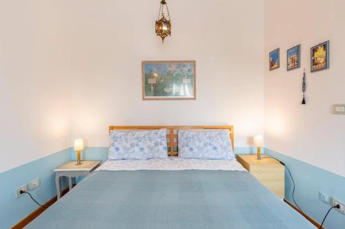 een slaapkamer met een blauw en wit bed met 2 lampen bij Praedia in Scafati