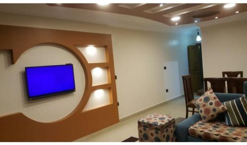 uma sala de estar com uma televisão azul na parede em City square em Alexandria