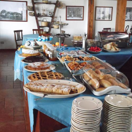 Agriturismo Torre dei Preti في بيسكيتشي: طاولة بها العديد من الأنواع المختلفة من الخبز والمعجنات