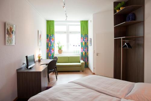 a bedroom with a bed and a desk with a computer at B&B Appartements Bischof & Bürk GbR in Tuttlingen