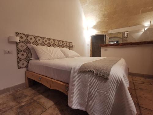 a bedroom with a large bed with a wooden headboard at DIONISO Bed & Wellness in Taranto