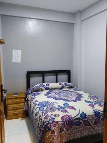 a bedroom with a bed with a colorful comforter at Lolitas Alojamiento Quillacollo in Cochabamba