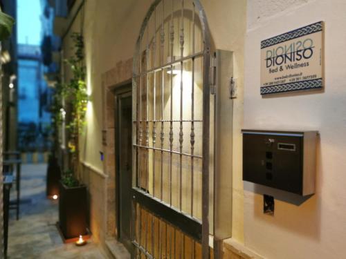 a door to a building with a sign on the wall at DIONISO Bed & Wellness in Taranto